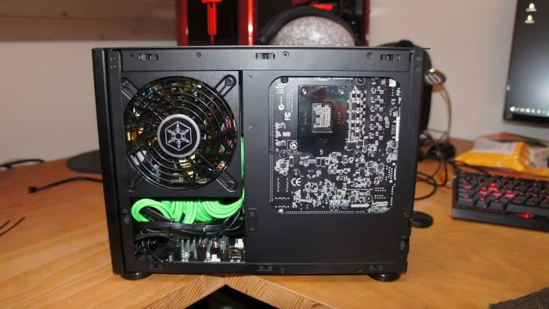 NCASE M1 Mamba Mod: Rückseite des Innenaufbaus mit Mainboard-Ausschnitt und grünen Kabeln